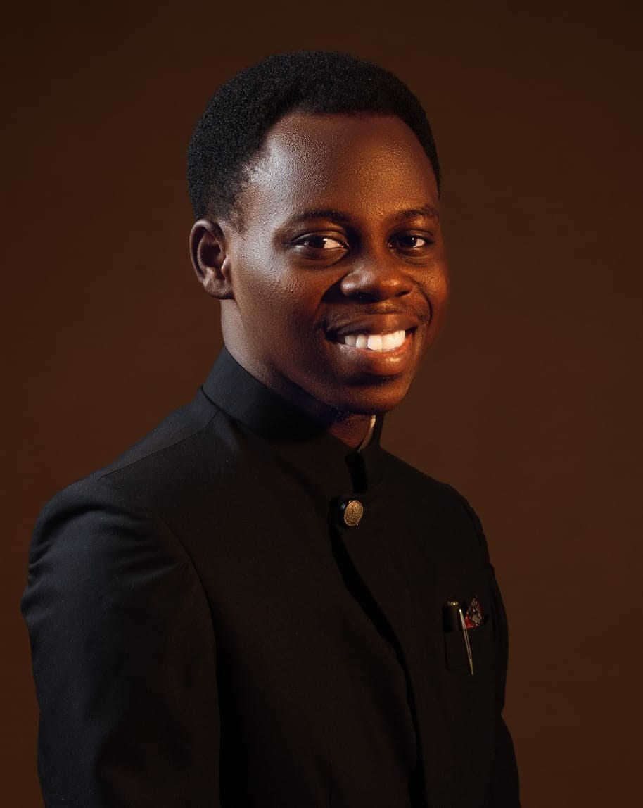 Moses Myles Adeola smiling in a black suit